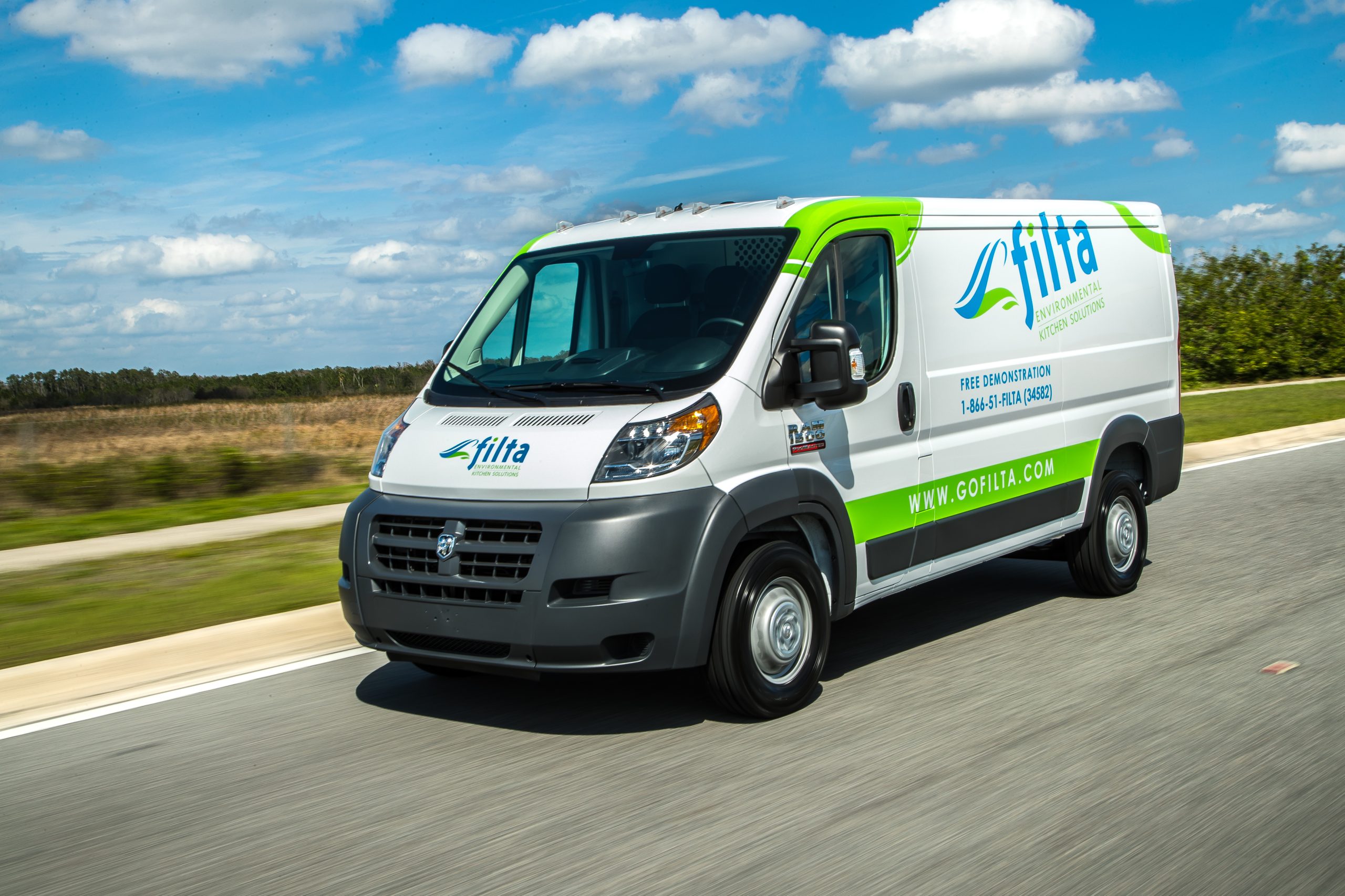Filta branded van in motion on a street with a blue sky
